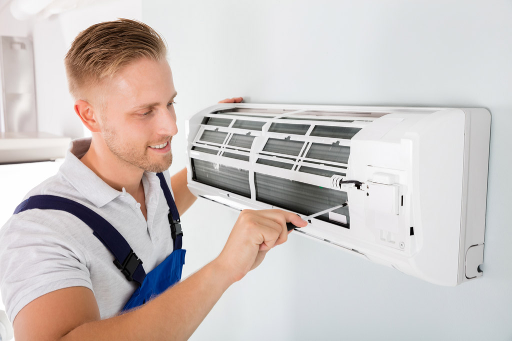 HVAC technician performing ductless air conditioning maintenance in Brighton