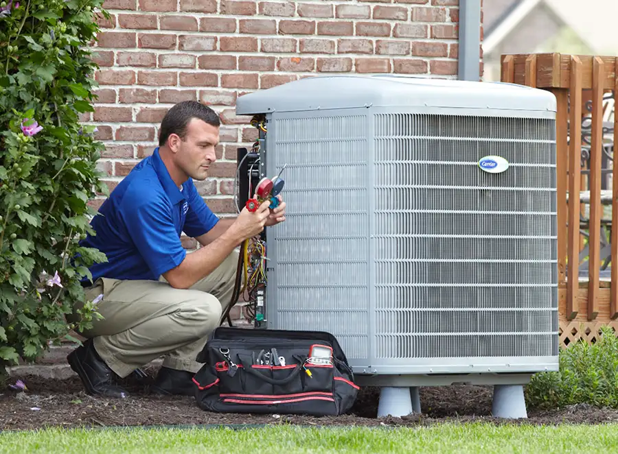 HVAC technician inspecting an outdoor air conditioning unit in Brighton