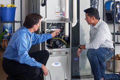 65df8c11f3e4c468cbd351a5_furnace repair vs replacement – Copy HVAC technician explaining furnace repair and maintenance to a homeowner in Brighton, CO