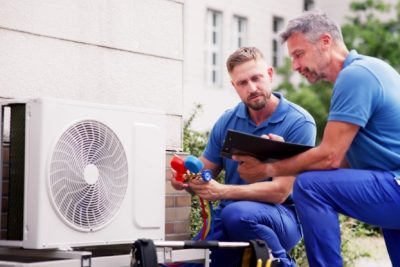 ac-installation-in-claremont-ca HVAC technicians reviewing an outdoor air conditioning unit in Brighton, CO